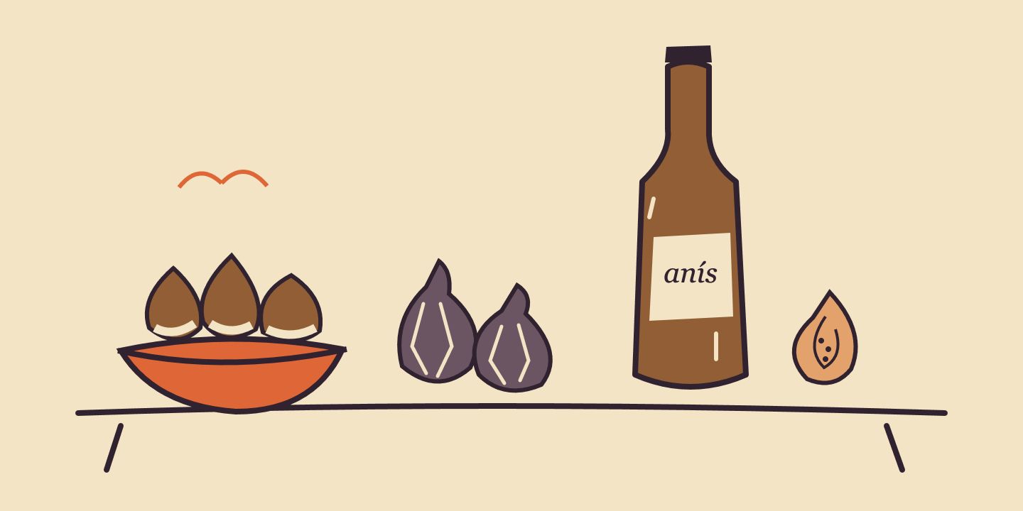 Castañas, higos secos y una botella de anís sobre la mesa